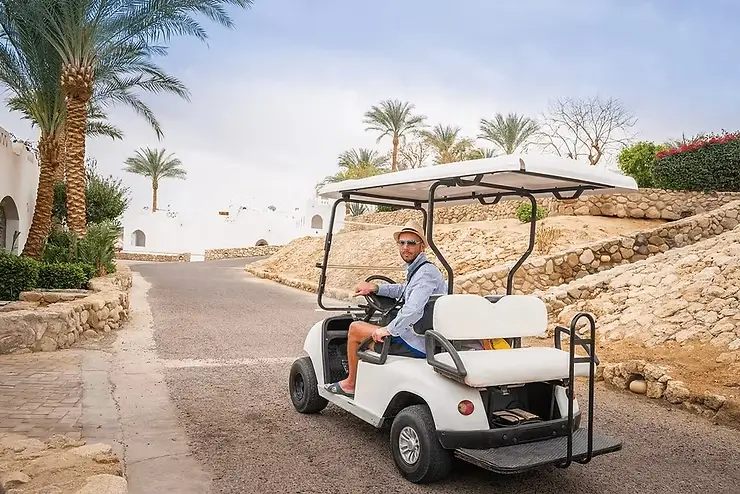 Person with a golf cart in a resort